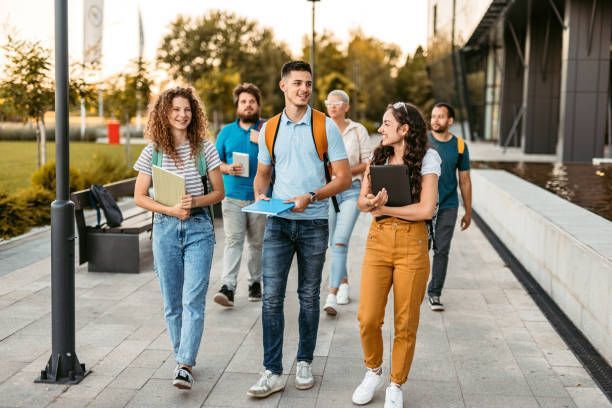 A group of young people are walking down a sidewalk