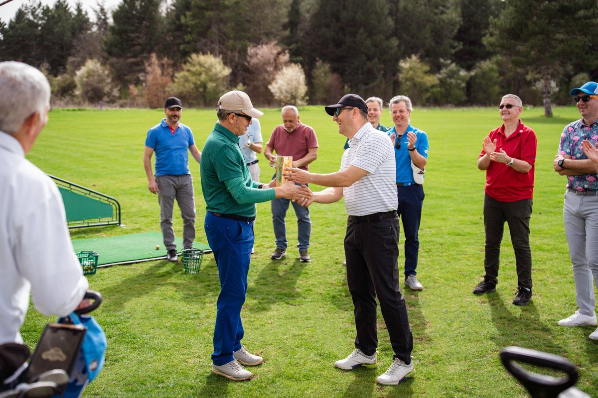 A group of men are shaking hands on a golf course