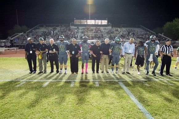 A group of people standing on top of a football field.
