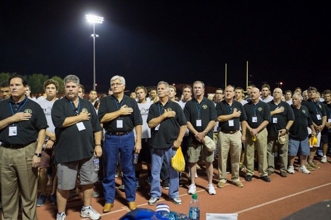 A group of men standing on a track with their hands on their chests