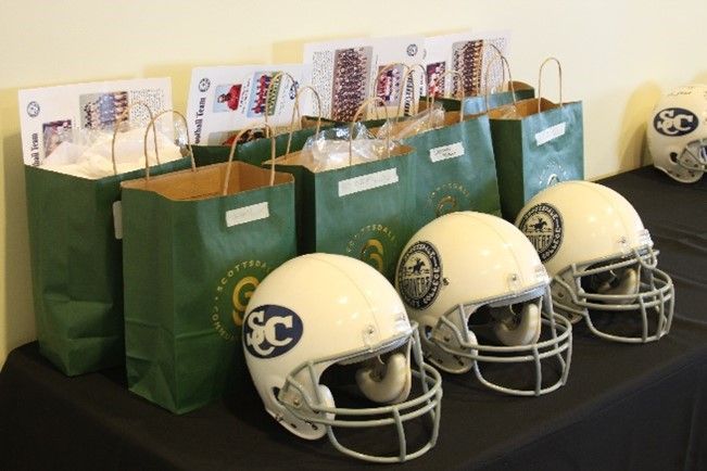 A row of football helmets with the letter cc on them