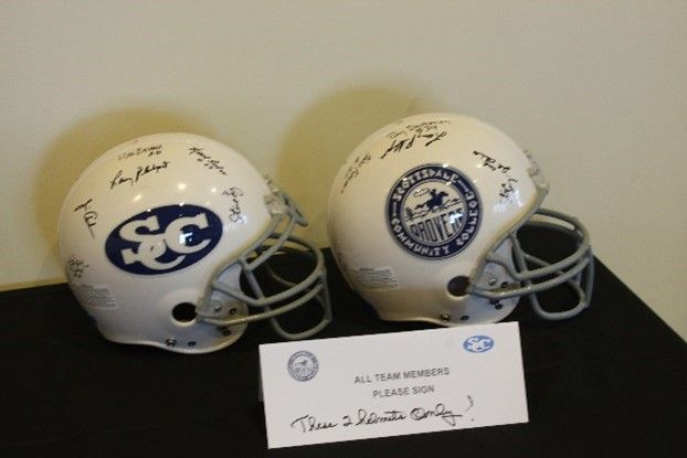 Two white football helmets with the letter sc on them