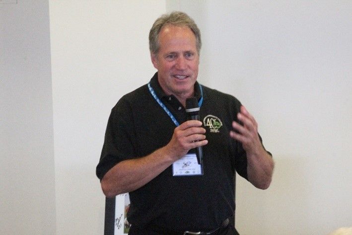 A man in a black shirt is talking into a microphone