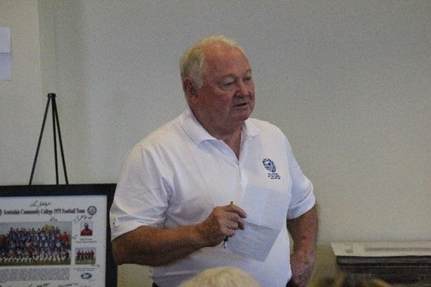 A man in a white shirt is giving a presentation