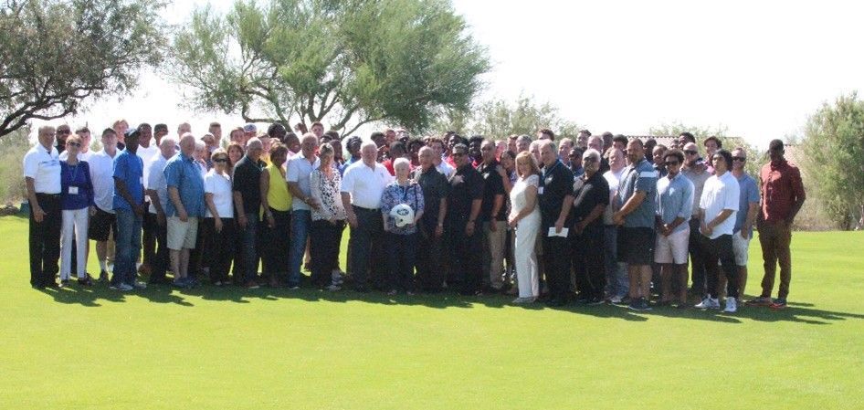A large group of people are standing in a grassy field.