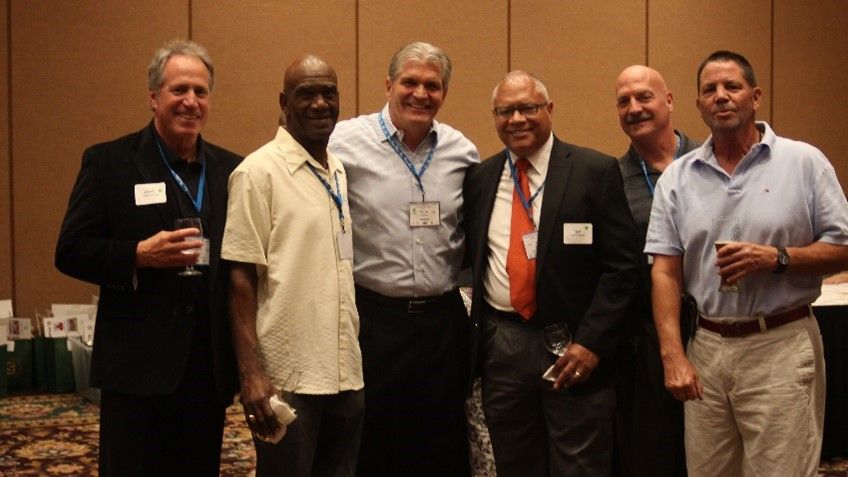 A group of men are posing for a picture in a room.