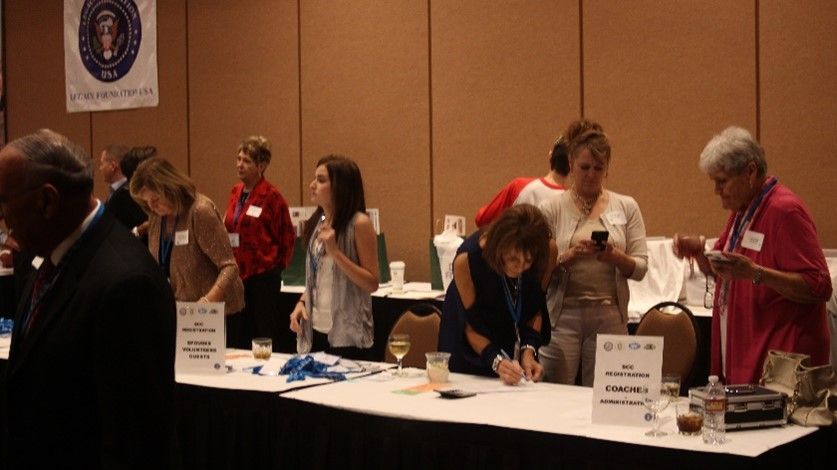 A group of people standing around a table with a sign that says ' a ' on it