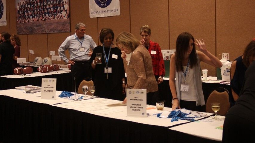 A group of people standing around a table with a sign that says ' volunteer ' on it