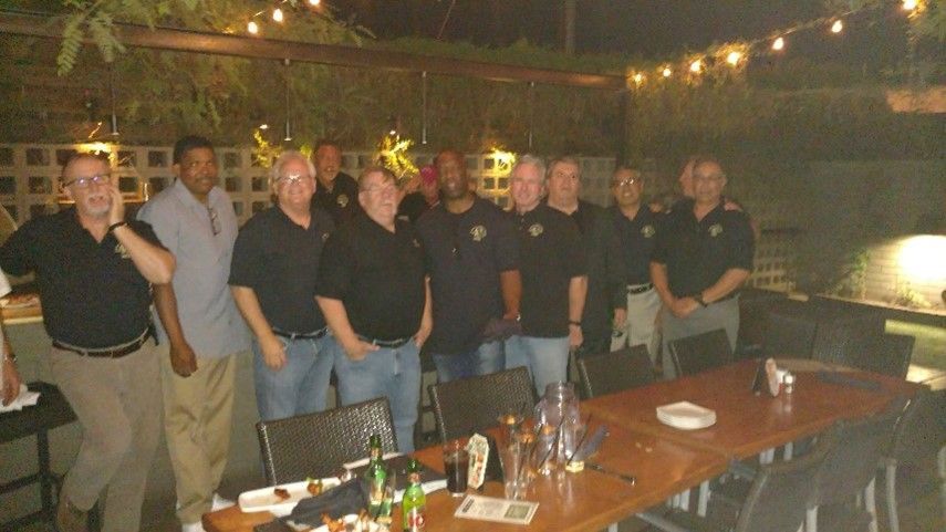 A group of men are posing for a picture in front of a table.