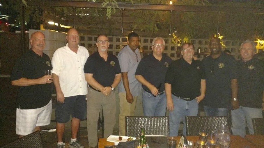 A group of men are posing for a picture in front of a table