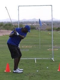 A man is swinging a golf club on a golf course.