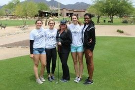 A group of women are posing for a picture on a golf course.
