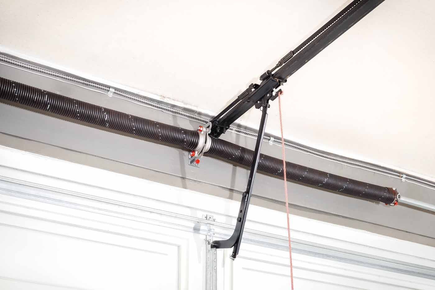 Garage door spring mechanism with a coiled spring and track.