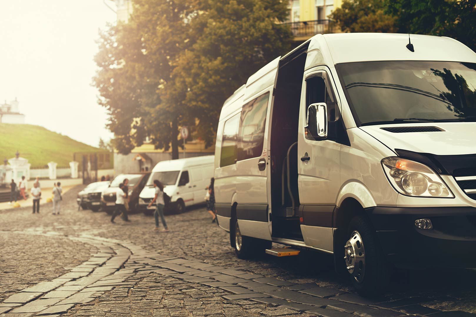 A White Van Is Parked on The Side of A Cobblestone Street — G & D Ross Bus Charters In Sunshine Coast, QLD