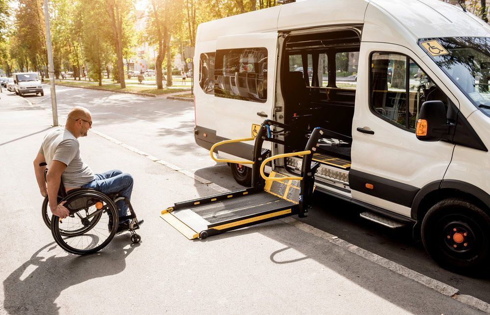 A Man in A Wheelchair Is Getting Into a Handicap Van — G & D Ross Bus Charters In Maleny, QLD