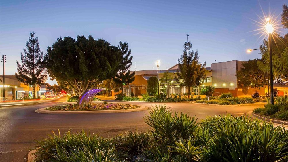 A Circular Driveway with Trees and Bushes in Front of A Building at Night — G & D Ross Bus Charters In Emerald, QLD