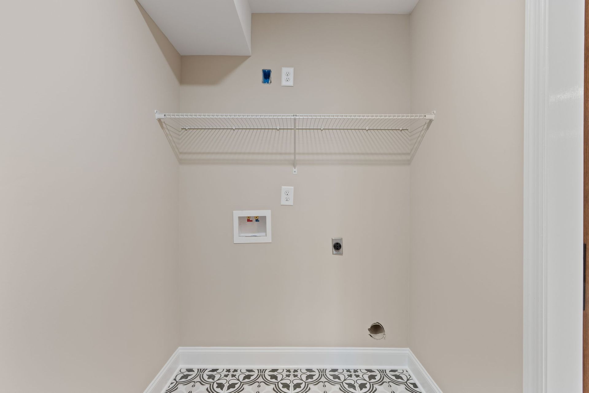 A laundry room with a washer and dryer and a shelf.