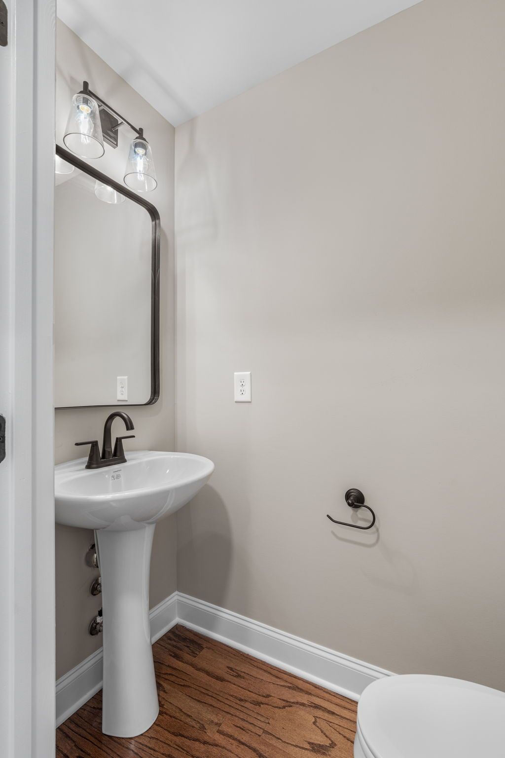 A bathroom with a sink , toilet and mirror.