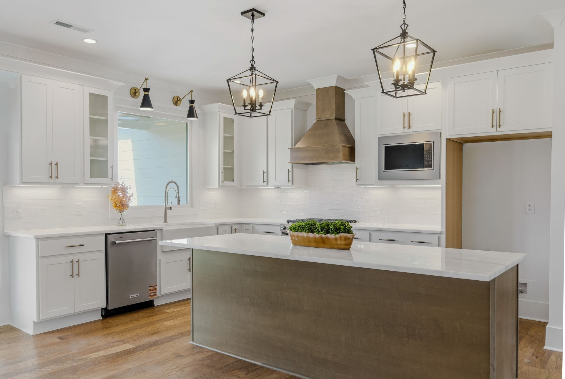 Bright modern kitchen with white cabinets, stainless appliances, and a large island with pendant lights