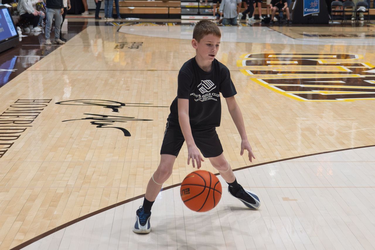 Young basketball player dribbling a ball on an indoor court during practice