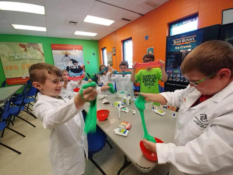 Children making slime at a classroom table with bright green and red containers