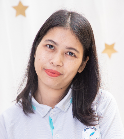 A woman wearing a white polo shirt is smiling for the camera.