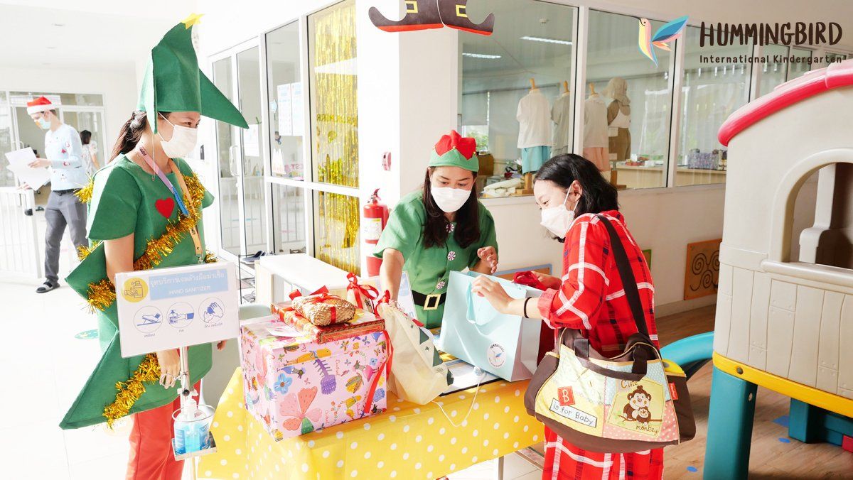 A group of people dressed as elves are standing around a table.