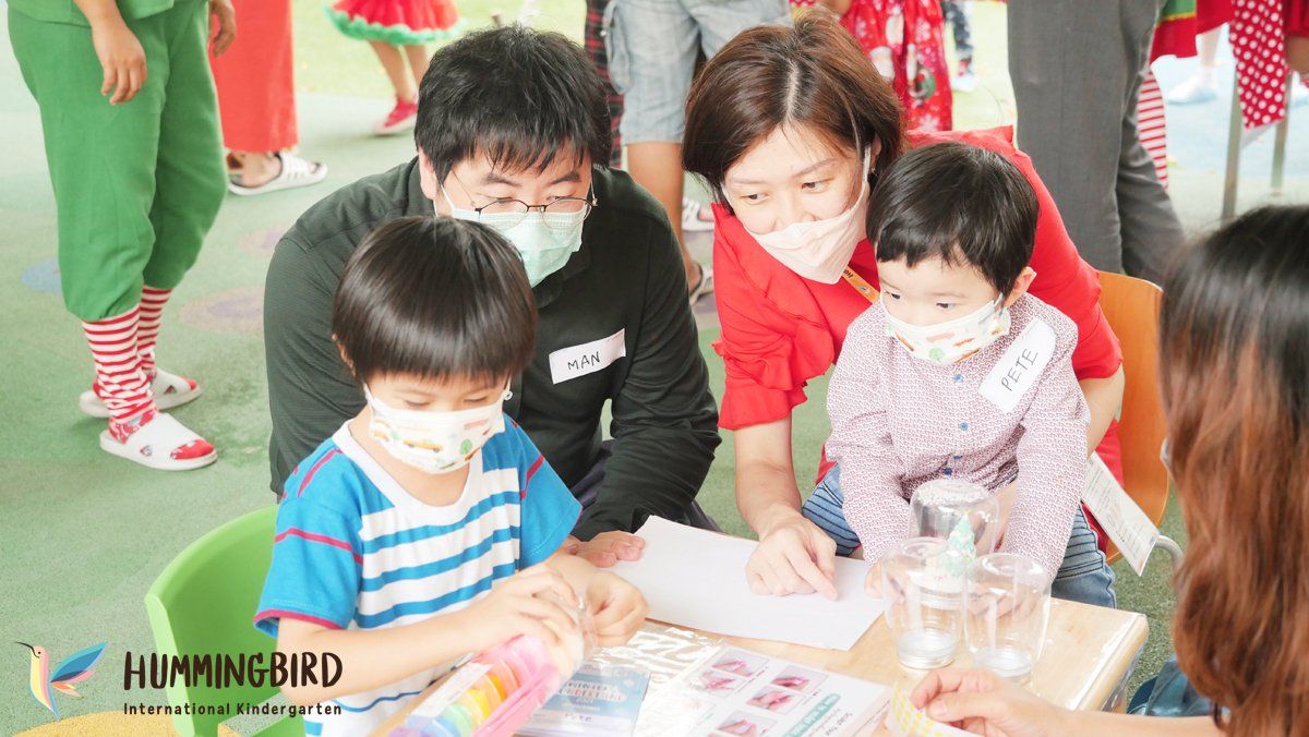 A group of people wearing face masks are sitting around a table.