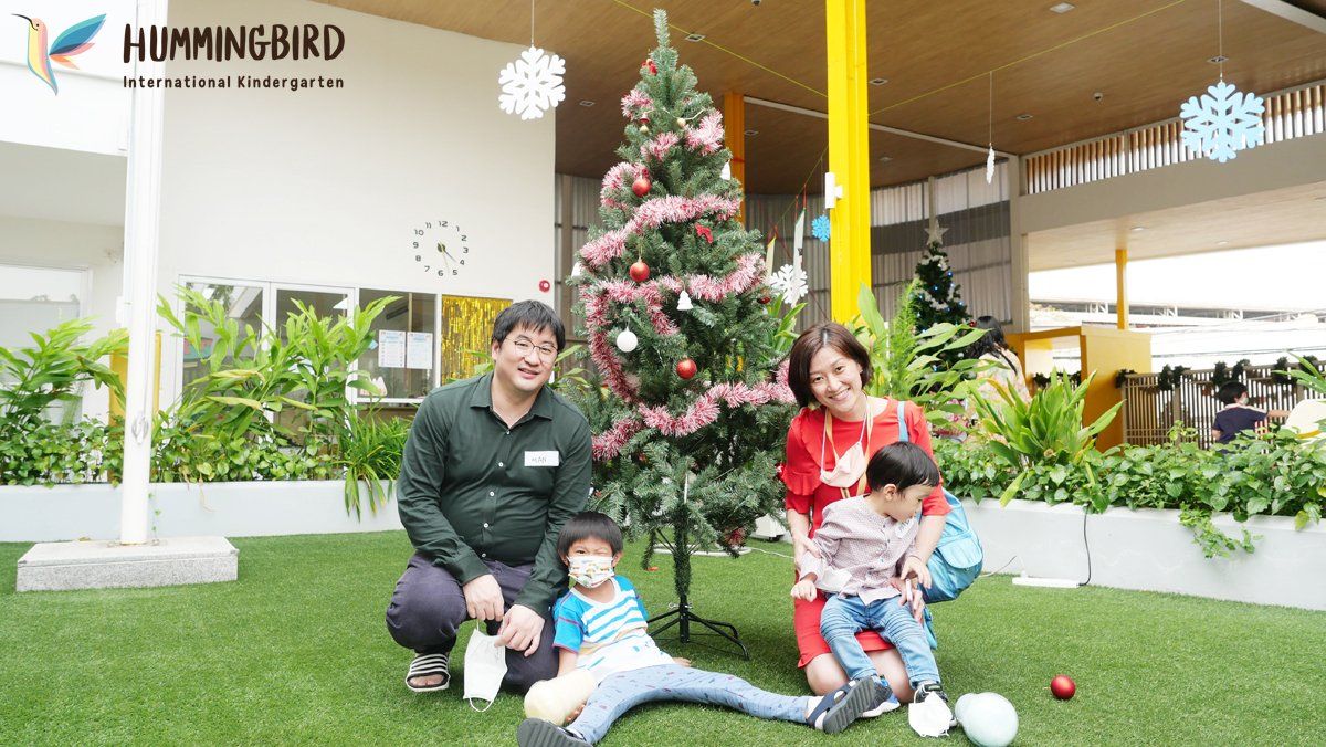 A family is posing for a picture in front of a christmas tree.