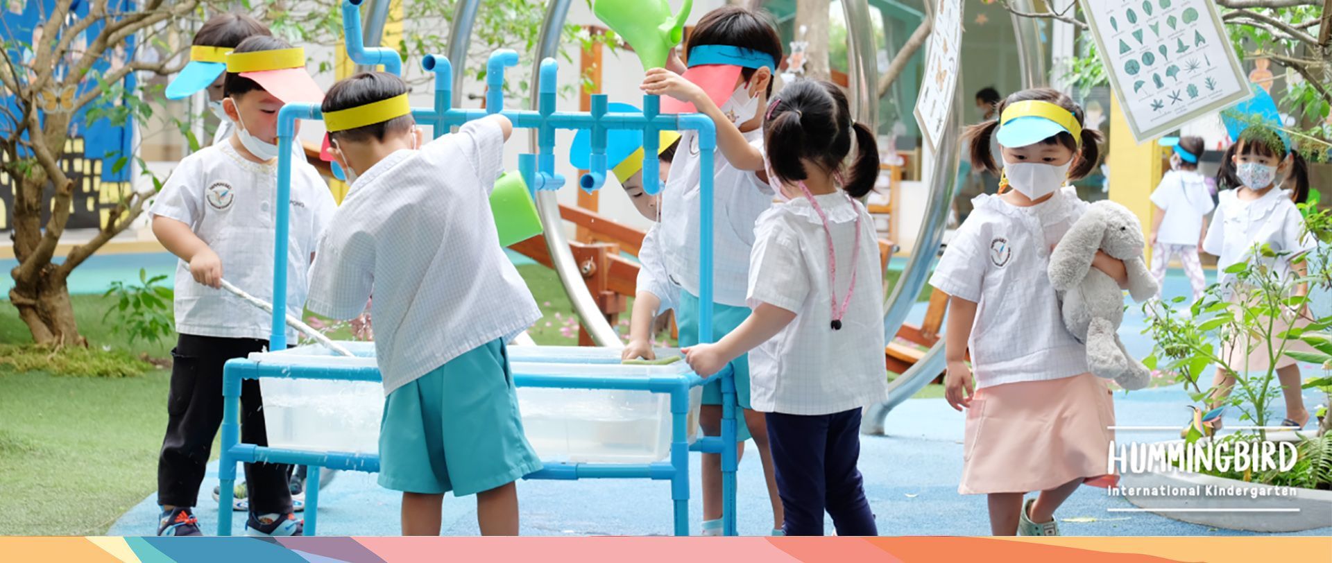 A group of children are standing around a table in a playground.