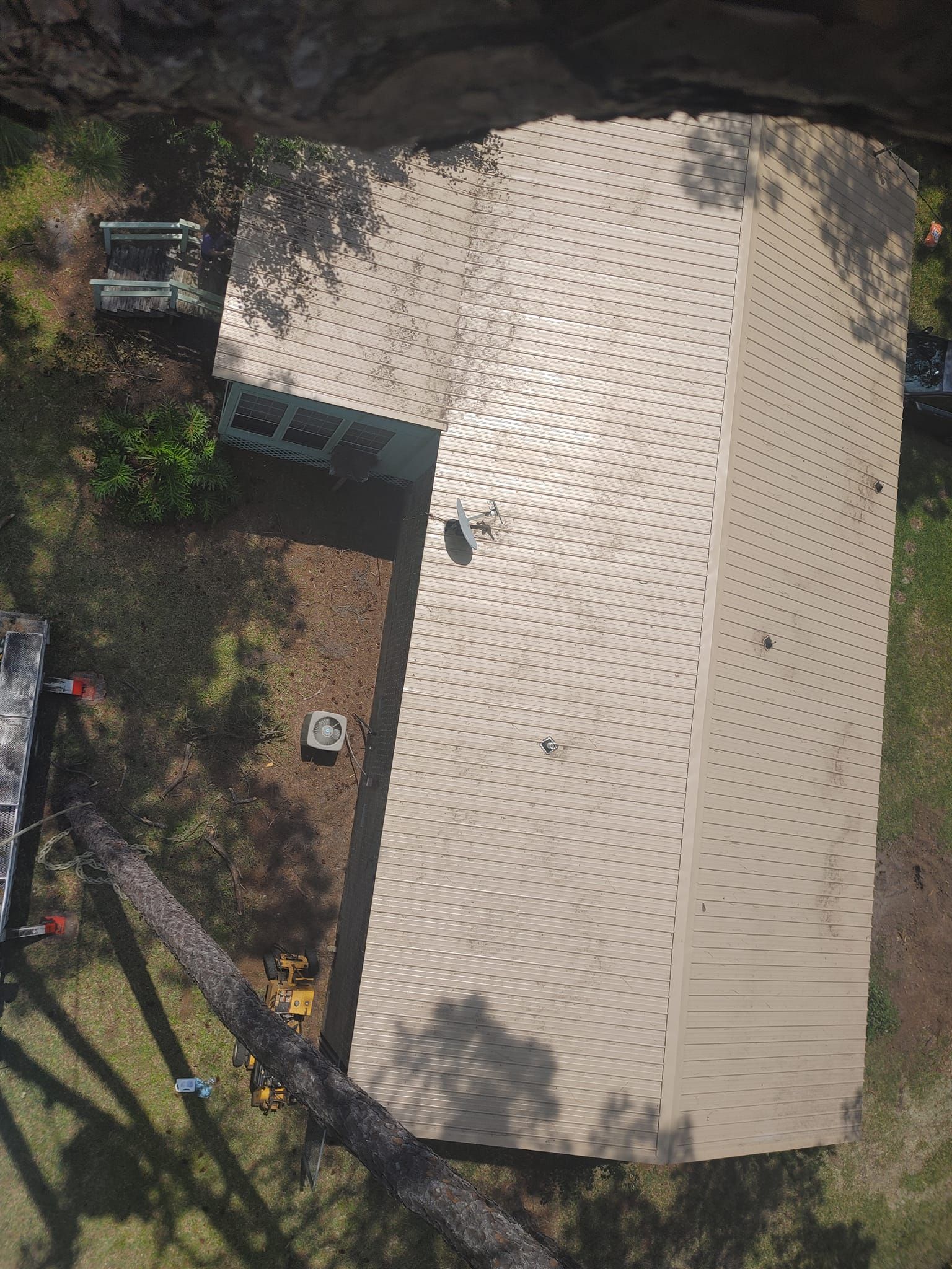 Overhead view of house with brown roof and surrounding trees.