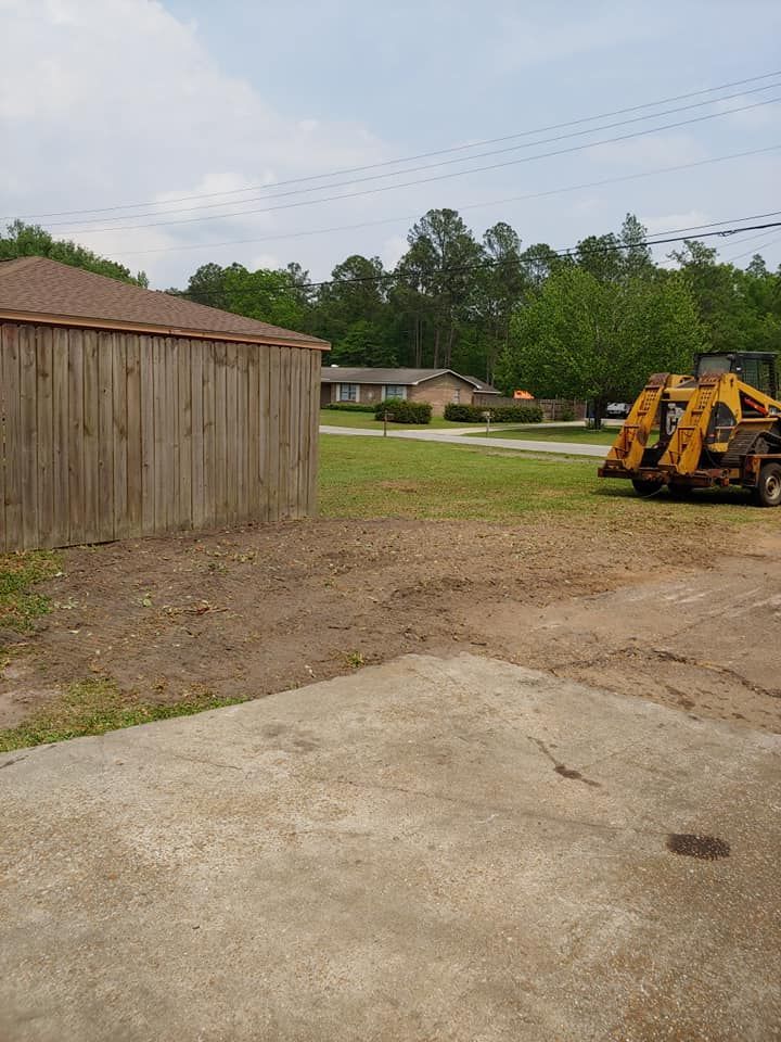 Wooden shed, yellow construction vehicle, grassy area, suburban setting, overcast sky.