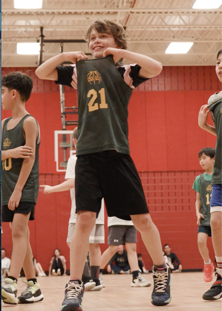 Basketball player in black jersey number 21 poses indoors on a gym court