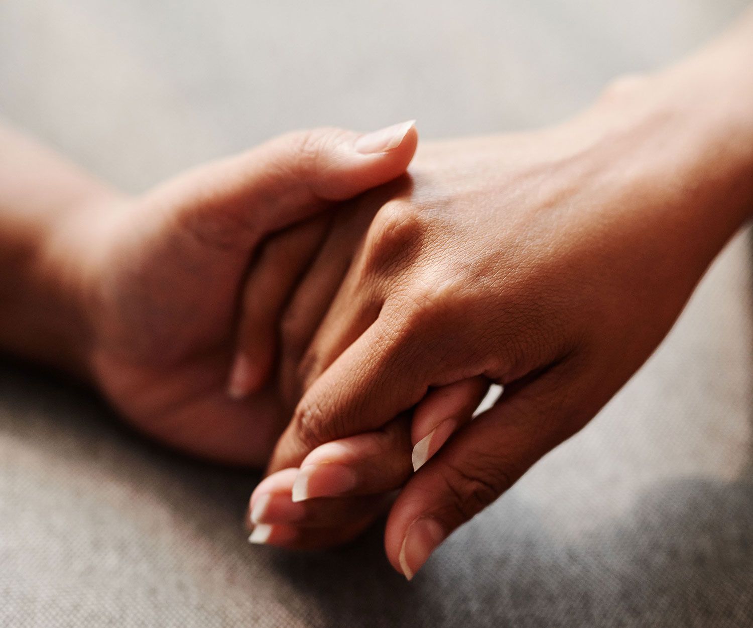 Two people holding hands in a gesture of support