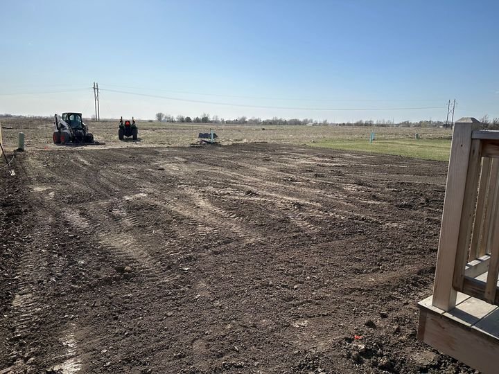 A house is being built in the middle of a dirt field.