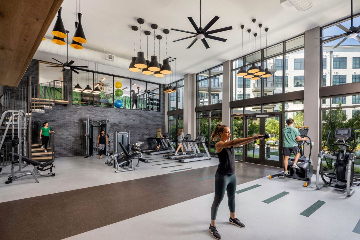 A woman is doing exercises in a large gym.