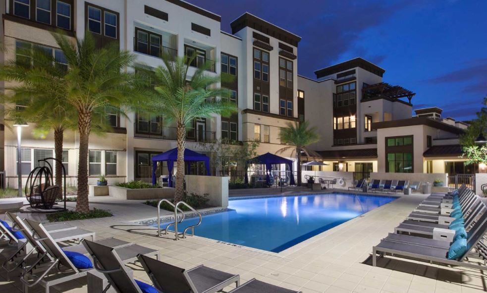 A large swimming pool in front of a building at night