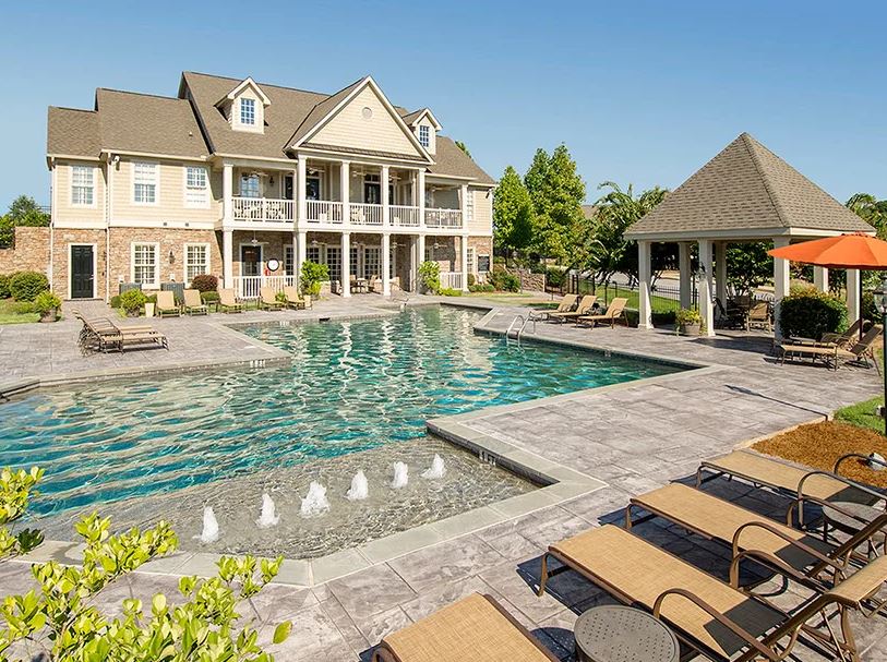 A large house with a large swimming pool in front of it.