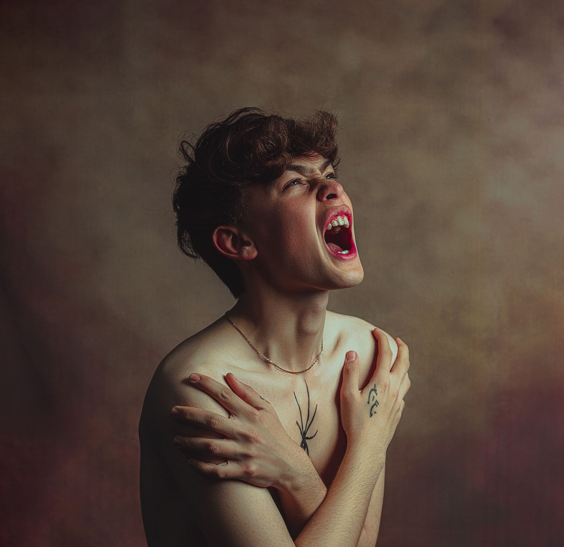 Person with curly hair singing passionately against a dark, textured background