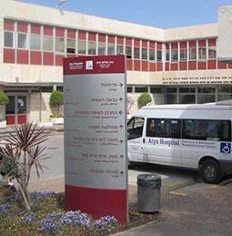 A white van that says alya hospital is parked in front of a building