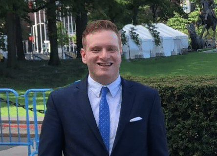 A man in a suit and tie is smiling for the camera.