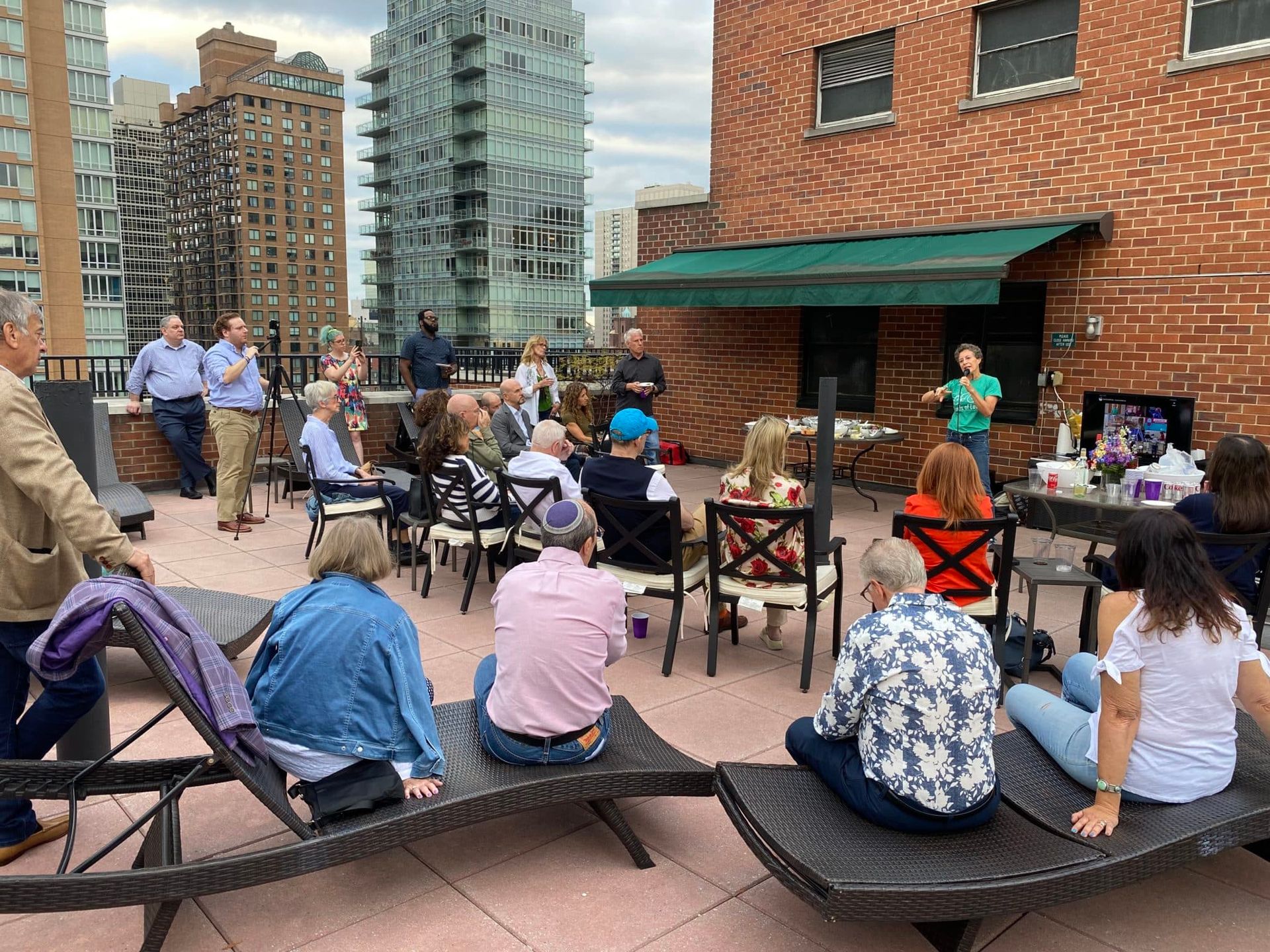 A group of people are sitting on lounge chairs on a rooftop.