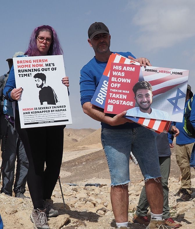 A group of people holding signs including one that says his arm was blown off
