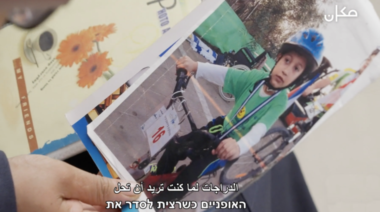 A person is holding a picture of a child wearing a helmet