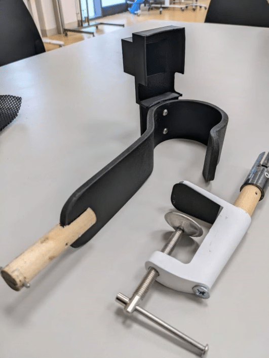 A clamp with a wooden handle is sitting on a table
