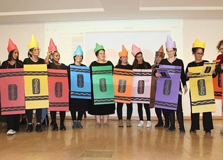 A group of people dressed as crayons are standing in a line.