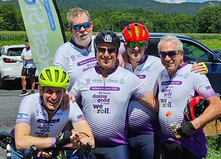 A group of men are posing for a picture while riding bicycles.