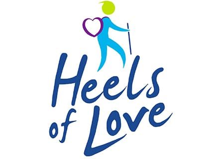 A logo for heels of love with a person holding a heart and a cane.