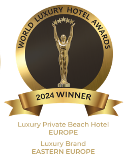 A golden circular World Luxury Hotel Awards 2024 badge featuring a trophy and text for regional hotel category winners.