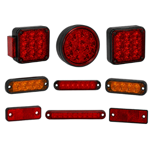 Assorted red and amber trailer lights and reflectors arranged on a white background